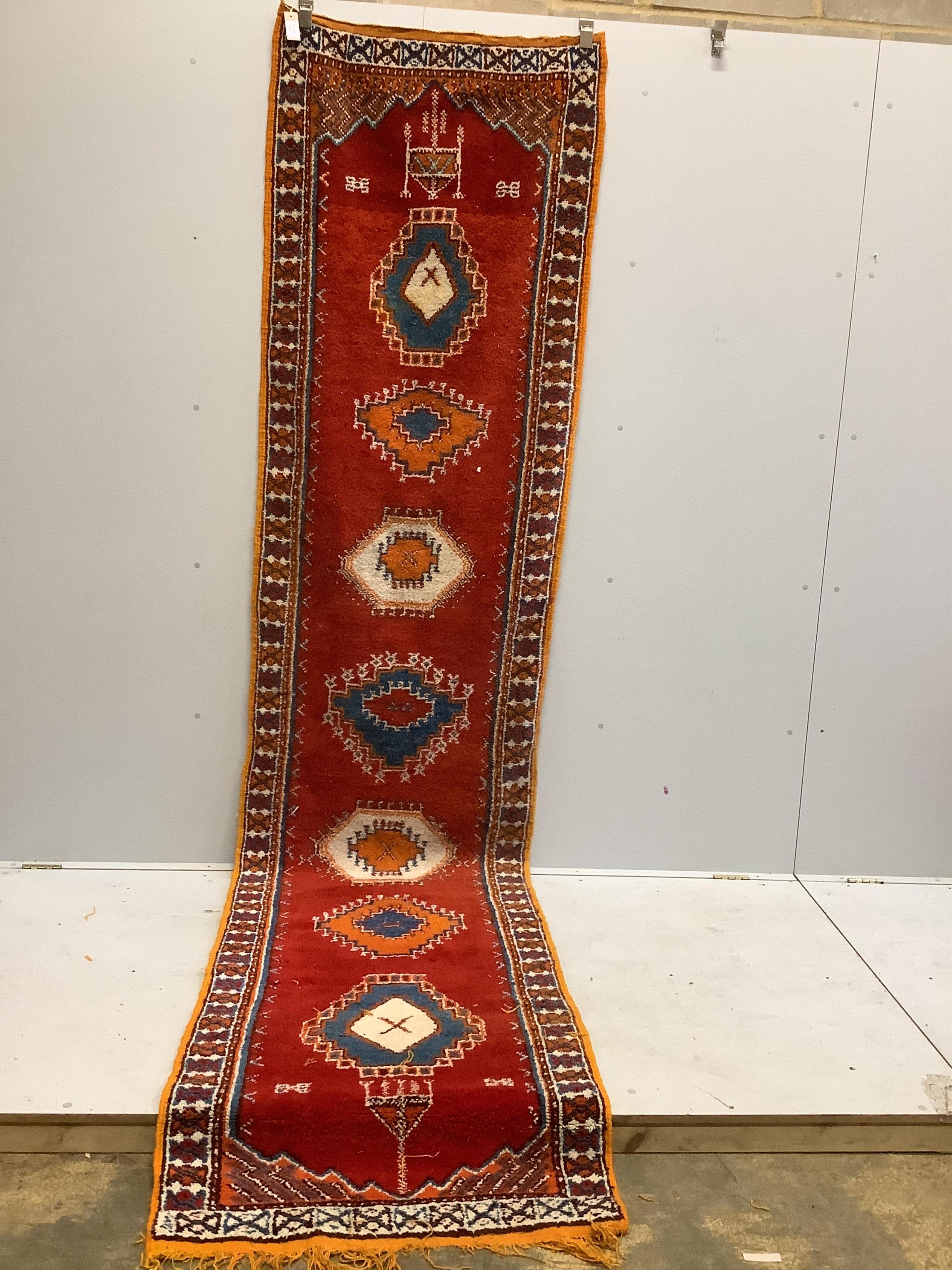 A Turkish red ground runner, woven with a row of hexagonal medallions, 375 x 89cm. Condition - fair